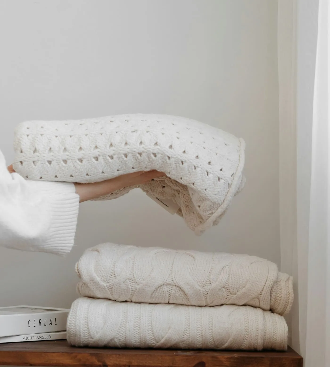 Sacs de rangement sous vide compressés contenant des couvertures, rangés sur une étagère de placard